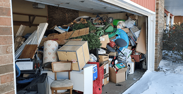 Homeowner sorting garage clutter before professional junk removal